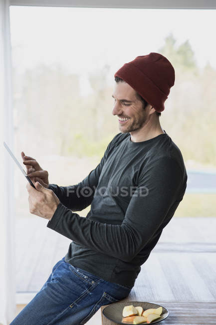 Hombre en casa usando tableta digital - foto de stock