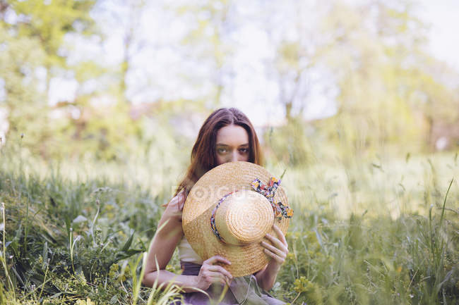 Jovem mulher agachada em um prado na primavera — Fotografia de Stock