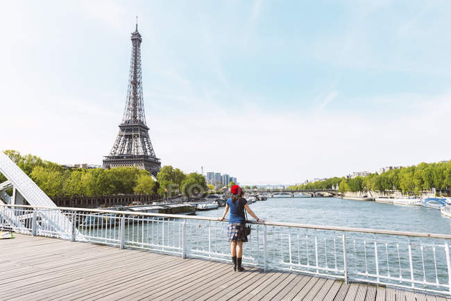 France, Paris, back view of woman wearing red beret looking at Eiffel ...