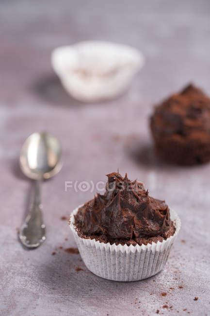 Primer plano de dos pasteles de taza de chocolate y cuchara de té en tela - foto de stock