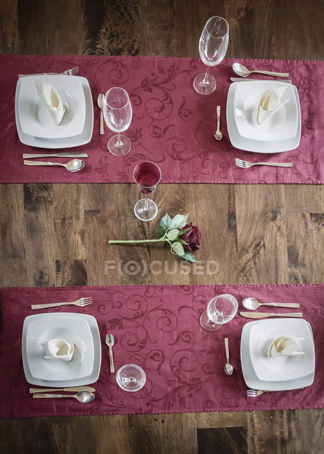 Table dressée en bois festive avec fleur au centre — Photo de stock