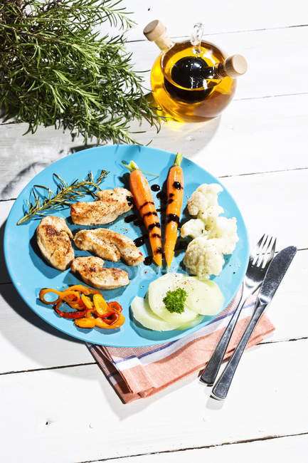 Closeup of slices of chicken filet with cauliflower, carrots and bell pepper on plate — Stock Photo