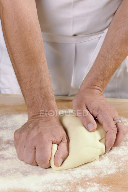 Hände eines Mannes, der Nudelteig für hausgemachte Tortelloni knetet — Stockfoto