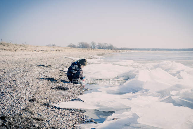 Allemagne, Mecklembourg-Poméranie occidentale, Rwegen, petit garçon jouant au bord de l'eau en hiver — Photo de stock
