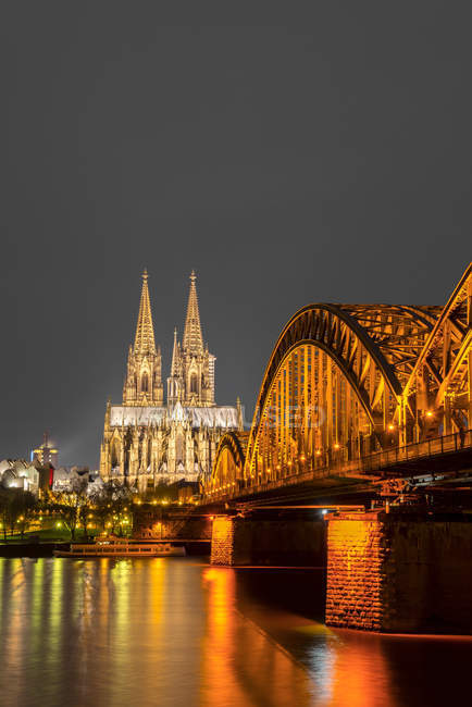 Alemanha, Renânia do Norte-Vestefália, Colônia, Colônia iluminada cathredral e Hohenzollern Bridge à noite — Fotografia de Stock