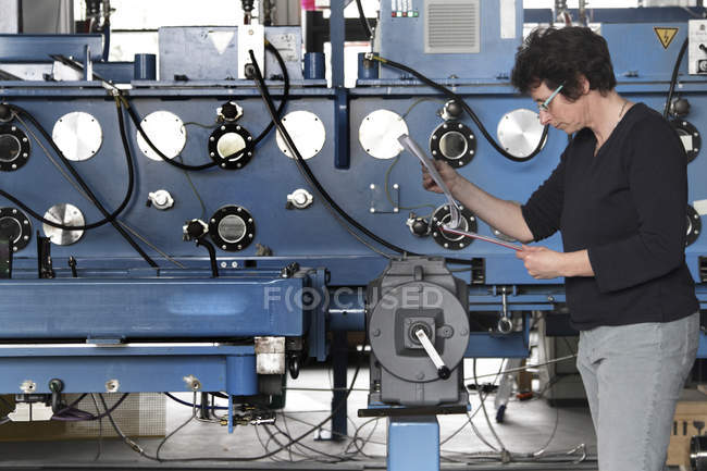 Technician with clipboard adjusting — Stock Photo
