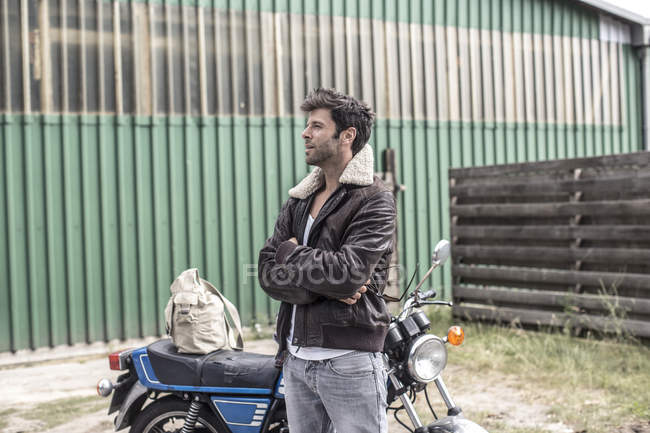 Homme élégant avec les bras croisés attendant devant la moto — Photo de stock
