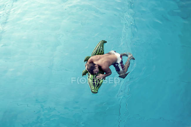 Giovane con giocattolo di nuoto galleggiante in acqua, vista dall'alto — Foto stock