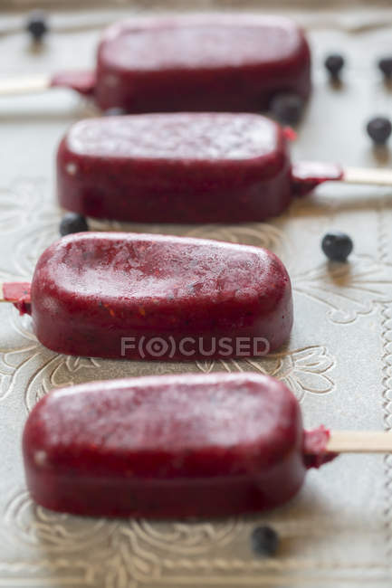 Close-up of row of four wild-berry ice lollies — Stock Photo