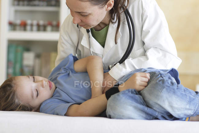 Pediatra examinando menina na clínica — Fotografia de Stock