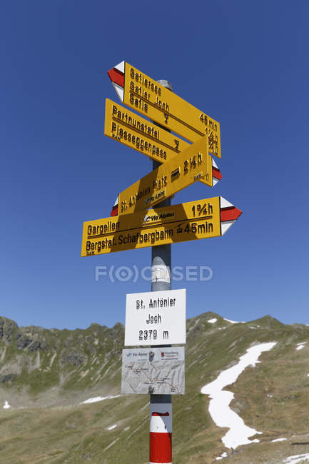 Österreich, Vorarlberg, Wegweiser am Antonier Joch und Hügel im Hintergrund — Stockfoto