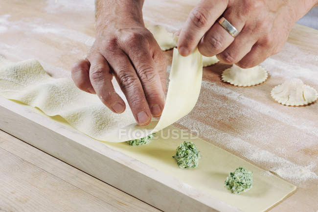 Man producing homemade tortelloni with spinach ricotta filling, close-up — Stock Photo