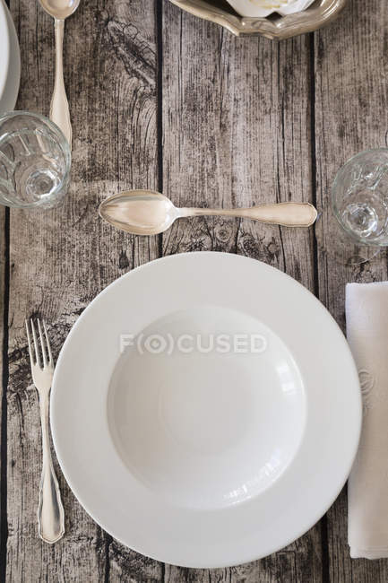 Place setting on wooden laid table — Stock Photo
