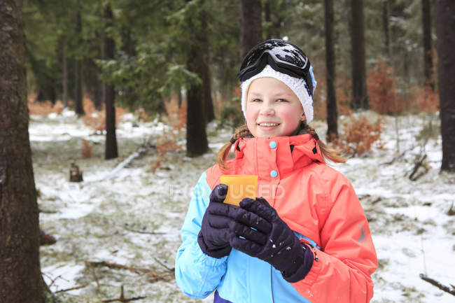 Sorridente ragazza adolescente indossa vestiti invernali colorati in possesso di tazza — Foto stock