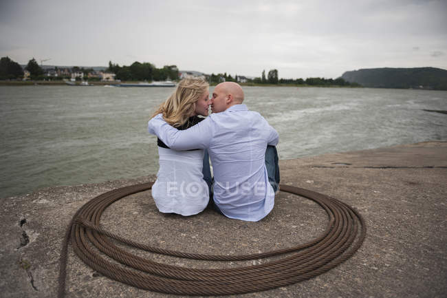 Alemanha, Renânia-Palatinado, jovem casal beijando à beira-mar do rio Reno — Fotografia de Stock