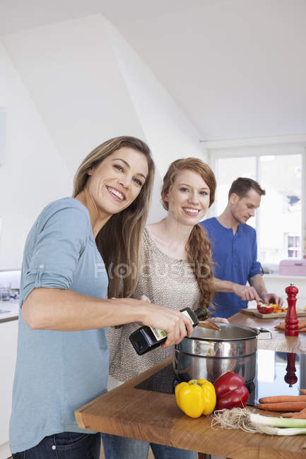 Tres amigos cocinando juntos - foto de stock