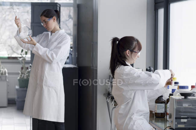 Deux jeunes étudiantes en chimie en laboratoire — Photo de stock