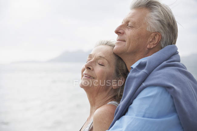 Senior couple hugging on beach — Stock Photo