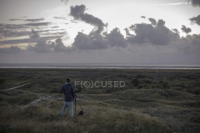 Pays-Bas, Homme debout avec caméra à la mer du Nord — Photo de stock
