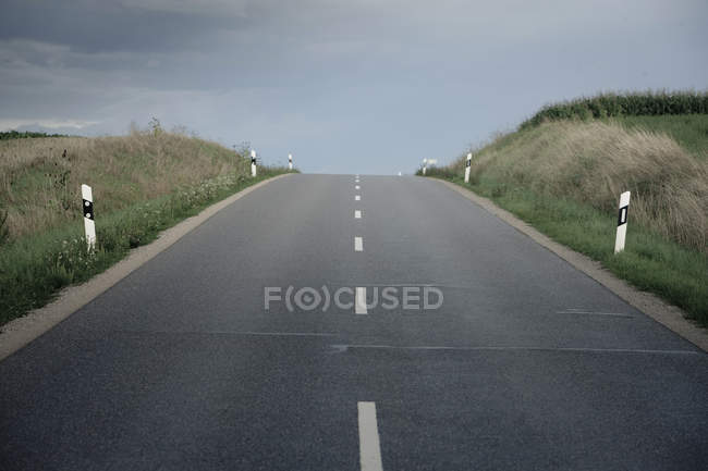 Germania, Ingolstadt, strada di campagna vuota con cielo nuvoloso — Foto stock