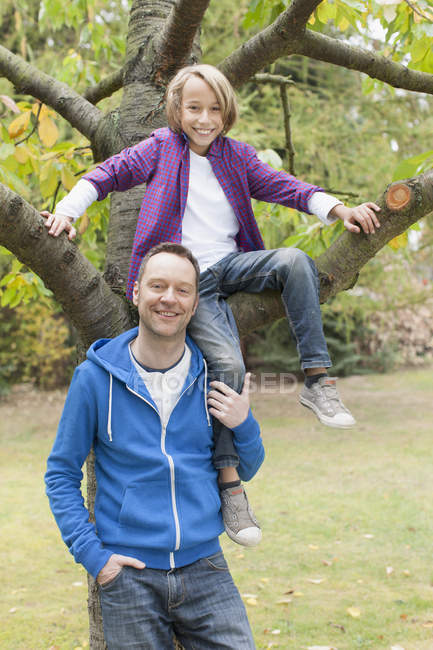 Vater steht neben Sohn auf Baum — Stockfoto