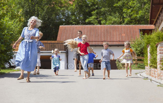 Femme dansant dans la rue avec un groupe d'enfants — Photo de stock