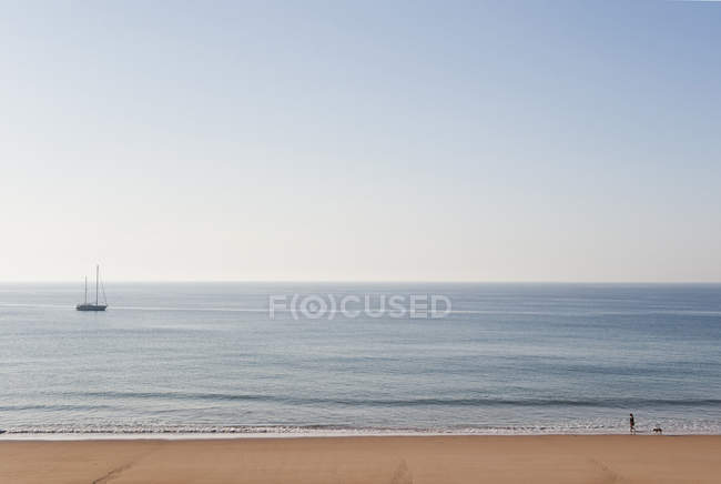 Portogallo, Veduta della spiaggia diurna e della barca a vela all'orizzonte — Foto stock