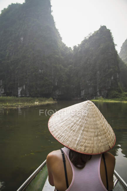 Vietnam, Ninh Binh, Joven turista sentado en booat en de Tom Coc - foto de stock