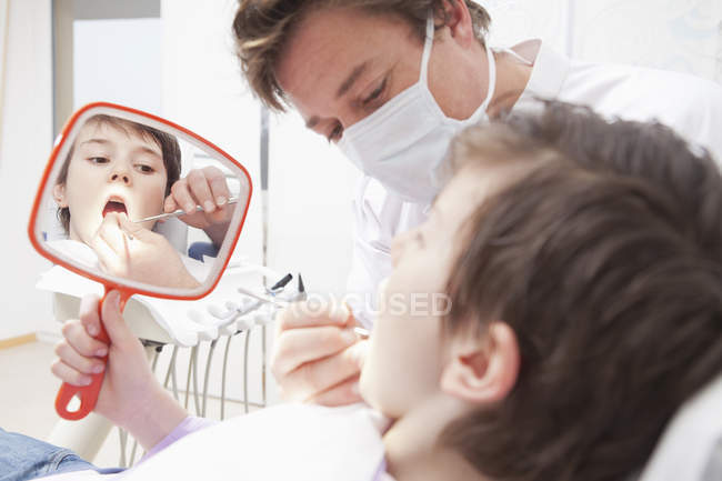 Стоматолог слідчим маленький пацієнт — стокове фото