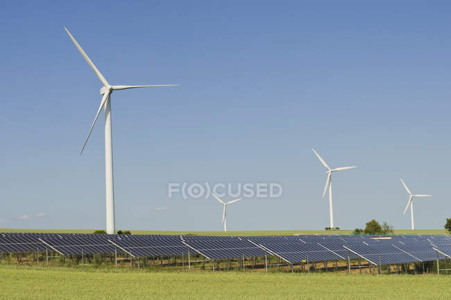 View of wind turbines with solar panels at daytime, Saxony, Germany ...