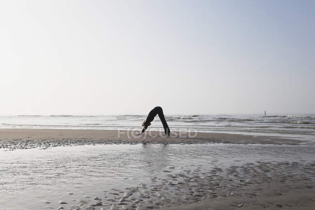 Belgique, Jeune femme faisant de l'exercice en mer du Nord — Photo de stock