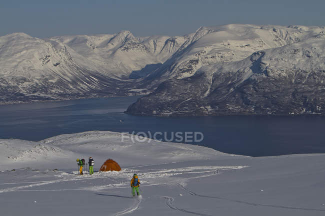Noruega, Homens em pé junto à tenda em terra nevada — Fotografia de Stock