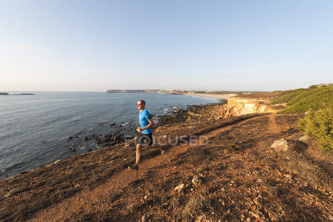 Portugal, Algarve, Homme mûr jogging par la côte — Photo de stock