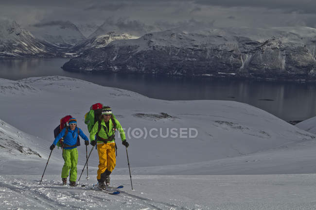 Norway, Lyngen, Skiers touring uphill — Stock Photo