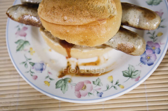 Close-up of Bratwurst sausages in roll on plate — Stock Photo
