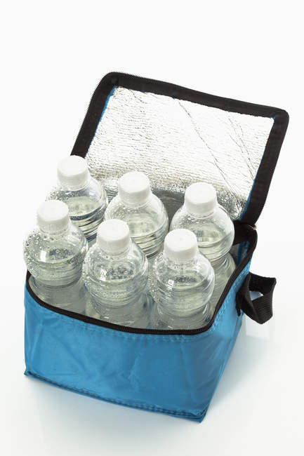 Six cool water bottles in blue bag on white background, close-up — Stock Photo