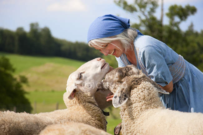 , Mulher madura brincando com ovelhas na fazenda — Fotografia de Stock