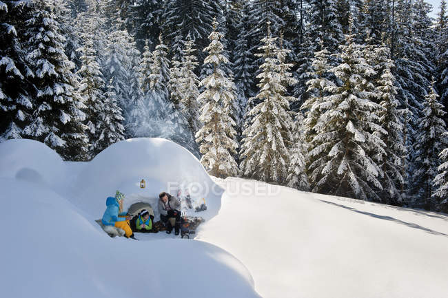 Сім'я, відпочиваючи біля сніг igloo у Зальцбурзі, Австрія — стокове фото