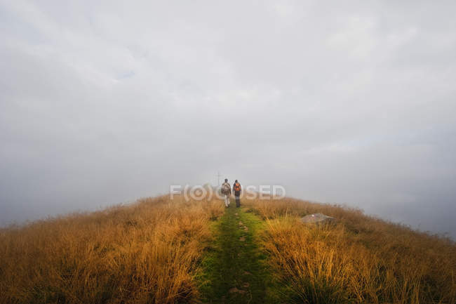 Uomo e donna che camminano in vetta — Foto stock