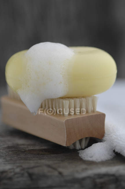 Мыло с мылом, полотенцем и щеткой для ногтей на деревянном столе — стоковое фото