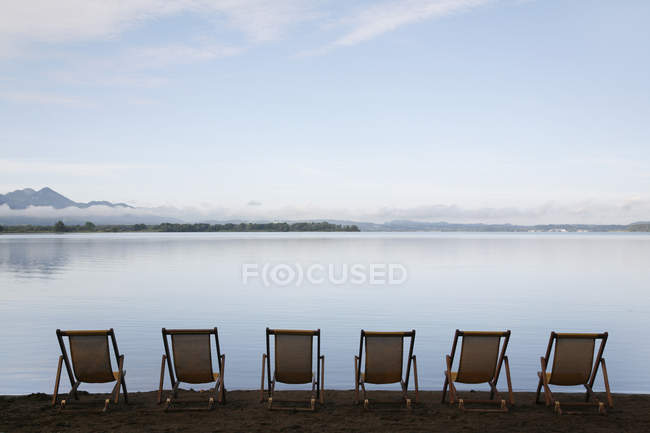 Allemagne, Bavière, Chiemsee, Rangée de chaises pliées au bord du lac — Photo de stock