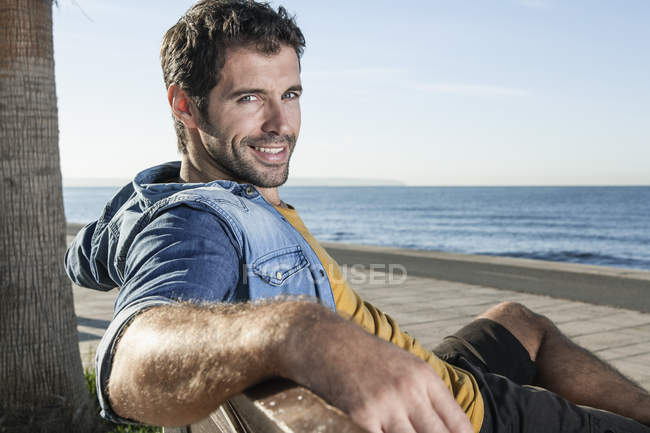 Spagna, Metà adulto seduto sulla panchina, sorridente, ritratto — Foto stock