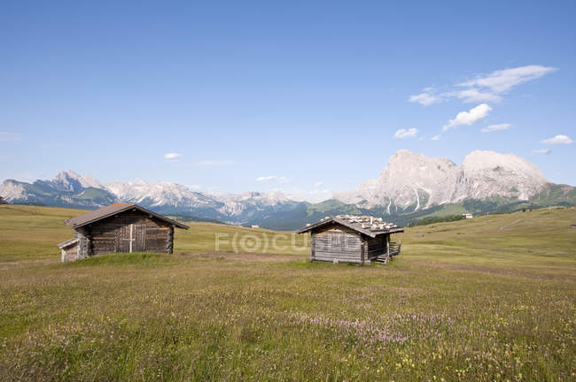 Cabañas alpinas con Langkofel y montañas Plattkofel - foto de stock