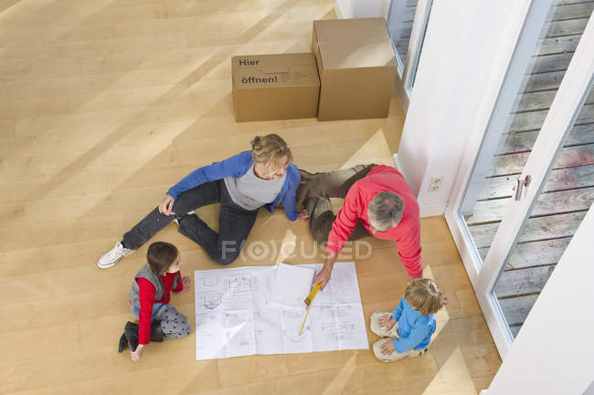 Щаслива родина, дивлячись на blueprint в будинку — стокове фото
