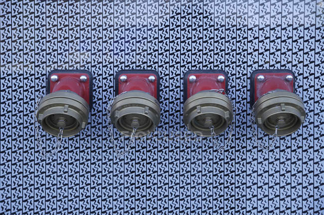 Row of water hydrants for fire on wall — Stock Photo