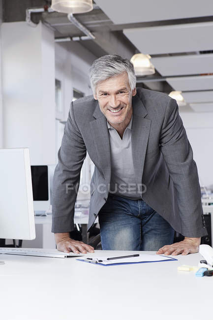 Homme mûr au bureau, souriant, portrait — Photo de stock