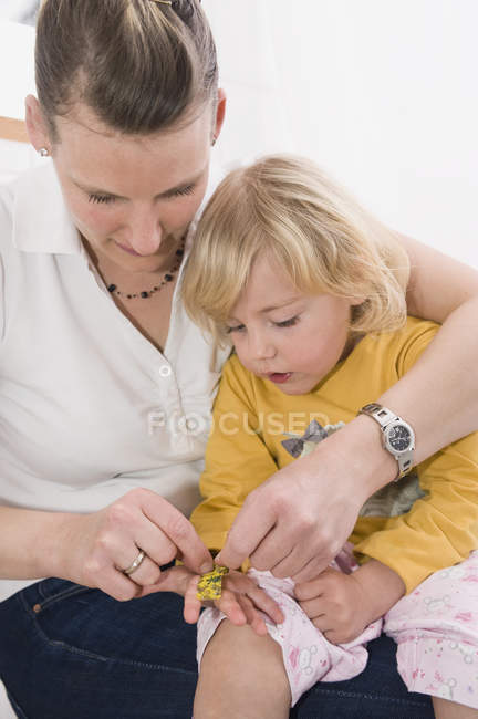 Hija mostrando vendaje - foto de stock