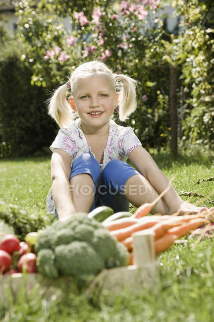 Girl sitting in vegetable garden — Stock Photo