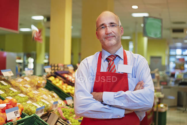 Hombre maduro de pie en el supermercado, sonriendo, retrato - foto de stock