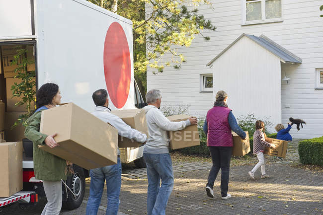 Família transportando caixa de papelão para casa em movimento — Fotografia de Stock
